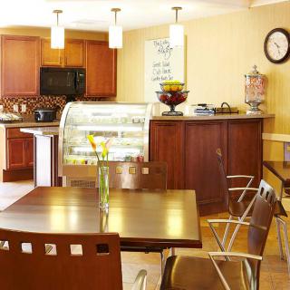 A cozy cafe interior with wooden furniture and a display case.