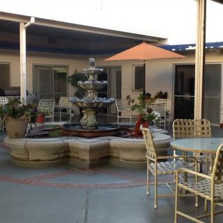 A tranquil courtyard featuring a fountain surrounded by outdoor seating and plants.