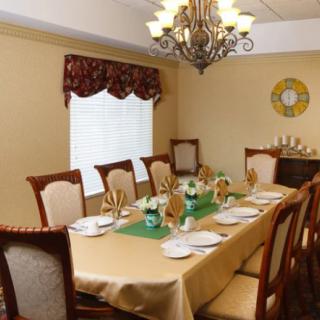 An elegantly decorated dining room with a chandelier and a fully set table.
