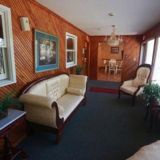 A cozy lobby area with wooden walls, featuring elegant seating and decor.