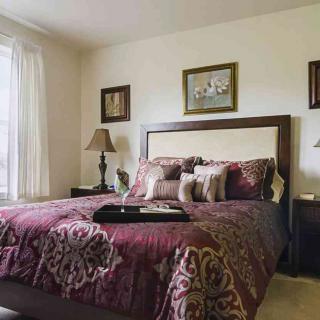 A cozy bedroom with elegant decor and a large bed adorned with patterned bedding.