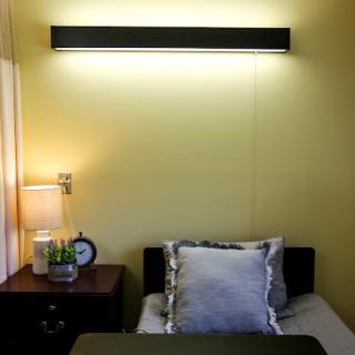 A cozy bedroom setup featuring a modern bed, stylish pillows, and a soft ambient light.
