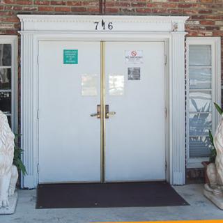 The entrance of a building featuring a pair of lion statues flanking the door.