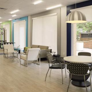A modern lounge area with comfortable seating, tables, and pendant lighting.