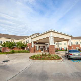 View of the entrance to a residential building with landscaped surroundings.