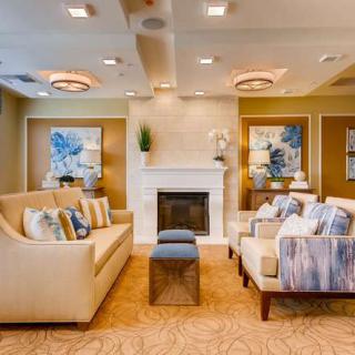 A modern living room with comfortable sofas, a central fireplace, and elegant decor.