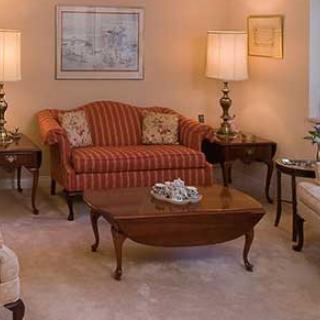 A cozy living room with a striped sofa, wooden coffee table, and warm lighting from table lamps.