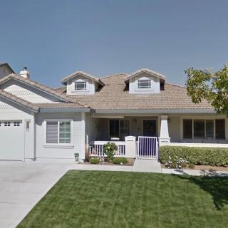 A suburban house with a well-maintained lawn and an attached garage.