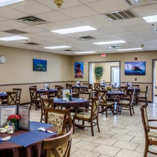 An empty dining room with neatly arranged tables and chairs, decorated with wall art.