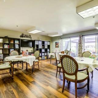 A well-lit dining area with elegant furniture and large windows.