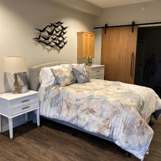 A beautifully designed modern bedroom featuring a cozy bed with stylish bedding and contemporary wall art.