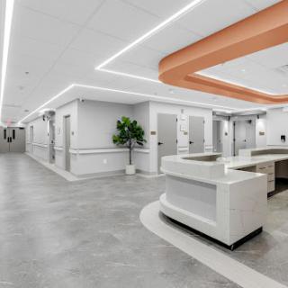 A modern and spacious interior of a healthcare facility, showcasing contemporary design with bright lighting and clean lines.