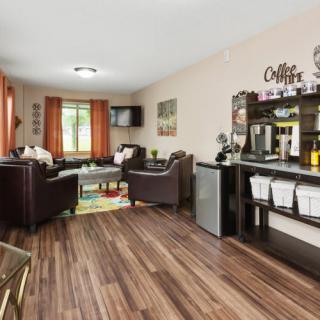 A cozy living room with a coffee station and modern decor.