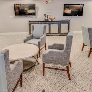 A modern lounge area featuring comfortable chairs and a round table, ideal for meetings or relaxation.
