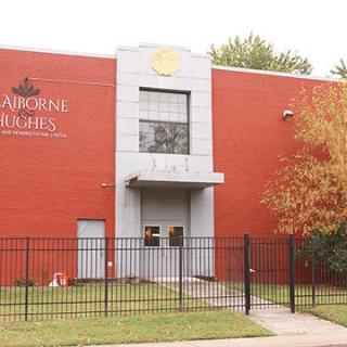 A brick school building with a fenced yard and entrance.