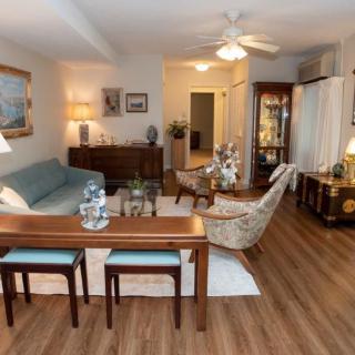 A cozy and well-furnished living room featuring a sofa, coffee table, and elegant decor with wood flooring.