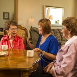 Three women enjoying a conversation over coffee at home.