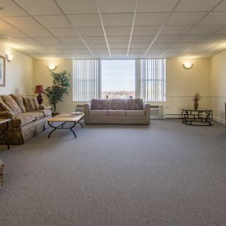 A spacious living room with sofas, a coffee table, and large windows.