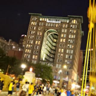 A lively evening scene in downtown, showcasing the illuminated Marriott building against the night sky.