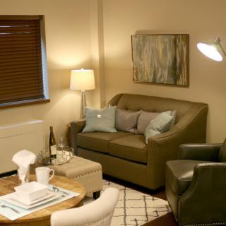 A cozy living room with a sofa, armchair, and warm lighting.