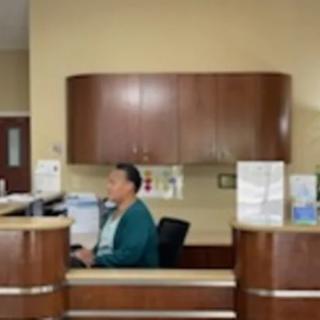 A person working at a reception desk in an office environment.