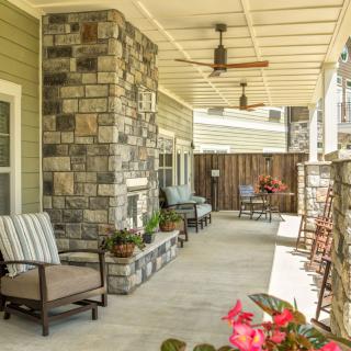 A cozy patio with comfortable seating and a stone accent wall, perfect for relaxation.