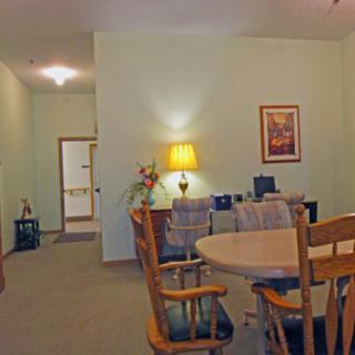 A cozy dining room with a wooden table, chairs, and soft lighting.