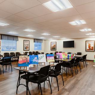 A well-lit conference room with tables and chairs, decorated with colorful artwork.