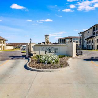 Entrance to a residential apartment complex with signage and landscaping.