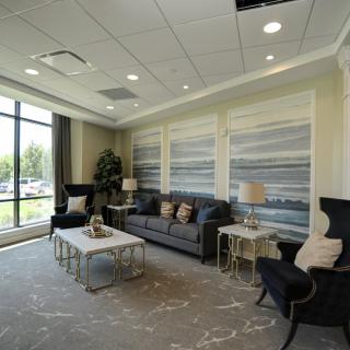 A modern living room interior featuring comfortable seating and large windows.
