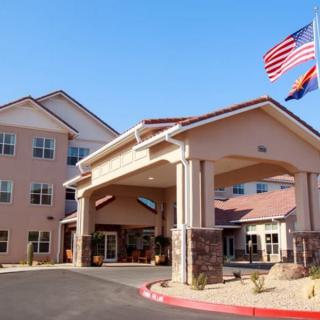 The front entrance of a multi-story building with flags flying overhead.