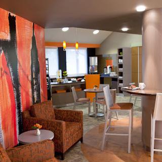 A modern lounge area featuring comfortable seating, vibrant wall art, and a cozy atmosphere.