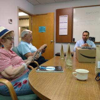 A group of individuals engaged in a discussion during a meeting in an office setting.