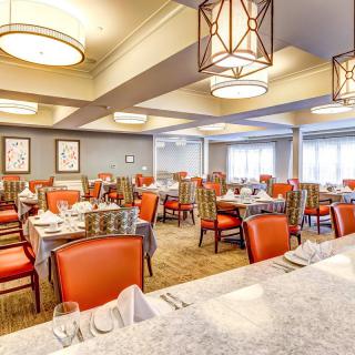 A well-lit restaurant dining area with neatly arranged tables and chairs.