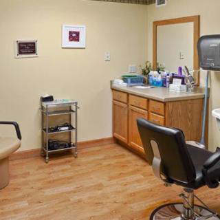 A cozy hair salon interior with a styling chair, mirror, and sink.