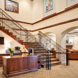 A well-designed office lobby with a central staircase and reception desk.