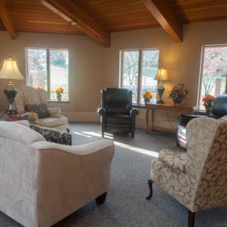 A cozy living room featuring a variety of seating options and plenty of natural light.