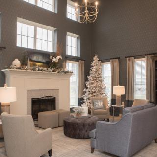 A beautifully decorated living room with a Christmas tree and fireplace, creating a cozy festive ambiance.