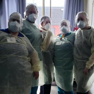 A dedicated team of healthcare professionals in protective gear, showcasing their commitment to patient care during challenging times.
