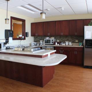 A modern kitchen with wooden cabinets, a central island, and various appliances.