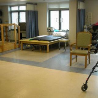 A rehabilitation room equipped for physical therapy sessions, featuring exercise equipment and seating.