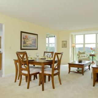 A bright and spacious dining room with wooden furniture and ample natural light.