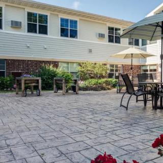 An inviting outdoor patio area with tables, chairs, and umbrellas next to a building.