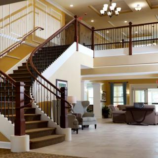 Spacious and elegant interior with a grand staircase and comfortable seating area.
