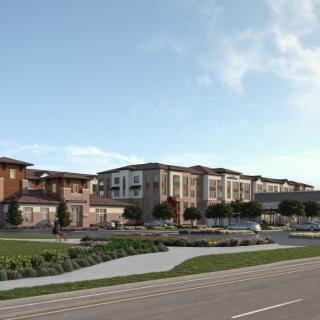 A modern residential complex featuring multiple apartment buildings with surrounding landscaping and a road in the foreground under a partly cloudy sky.