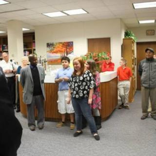 A group of people gathered in an office setting for a meeting.