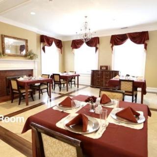 Elegant dining room with red table settings and classic decor.