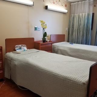 A view of a hospital patient room with two beds and calming decor.