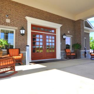 A welcoming entrance featuring a brick facade and comfortable outdoor seating.