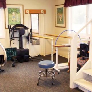 A physical therapy room equipped with various rehabilitation and exercise devices.